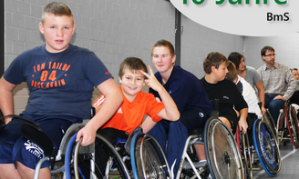 Kinder im Rollstuhl stehen hintereinander